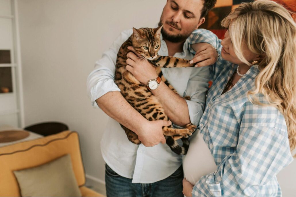 A couple holding a cat.